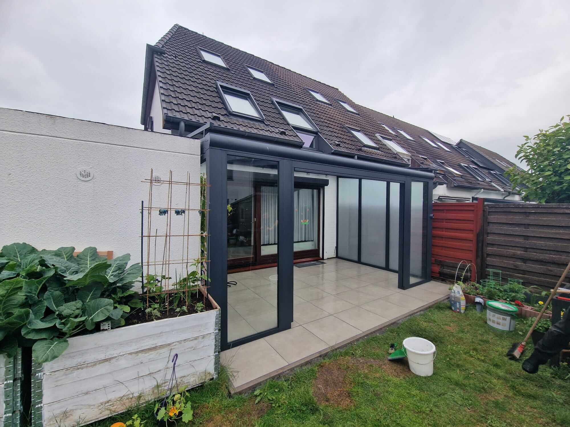 Großzügige Terrassenüberdachung mit dunkler Aluminiumkonstruktion