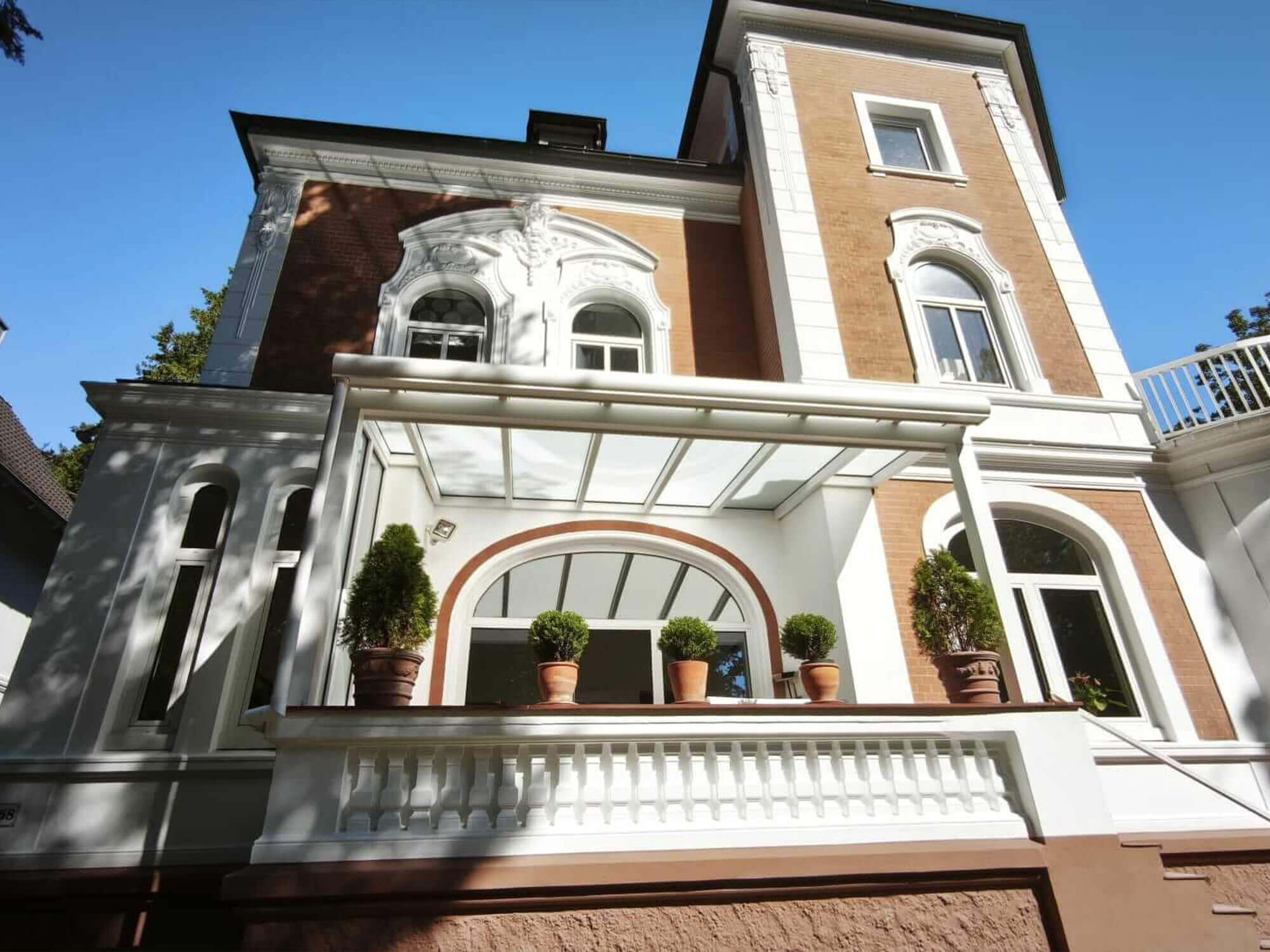 Terrassenüberdachung an einem Wohnhaus mit Balkon